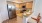 a kitchen with a fridge and chairs